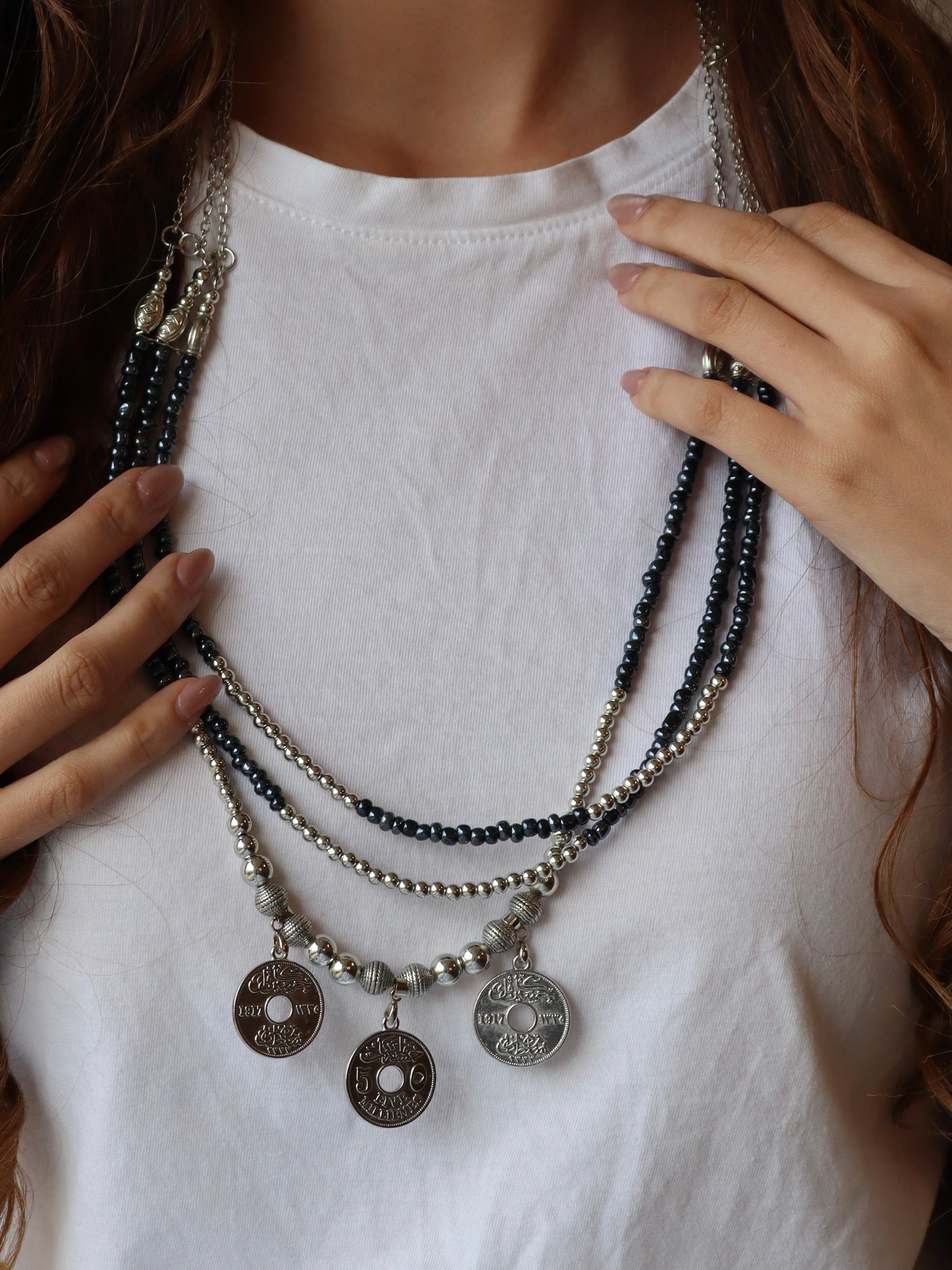blue triple layered beaded necklace with three silver coins