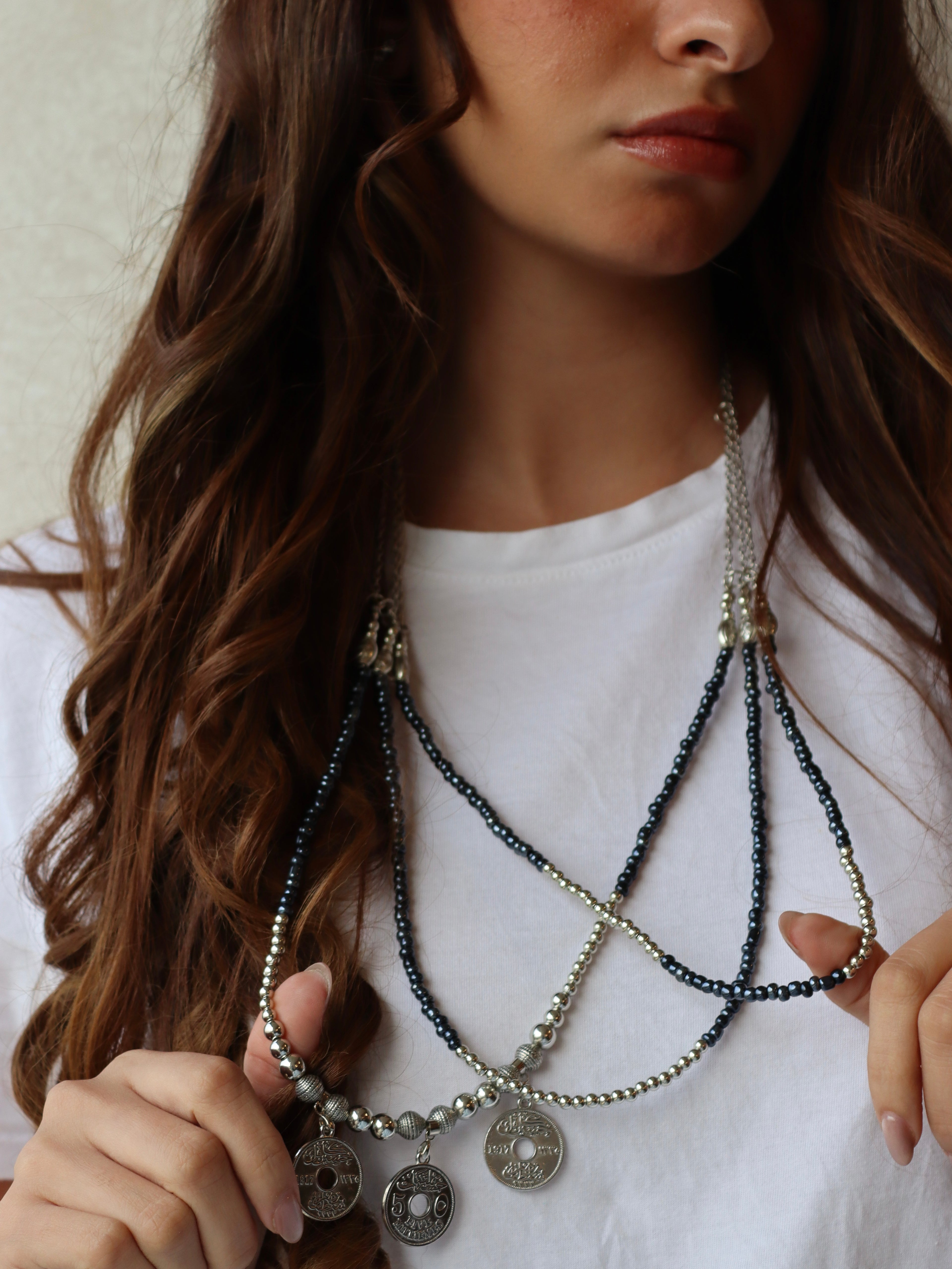 blue triple layered beaded necklace with three silver coins