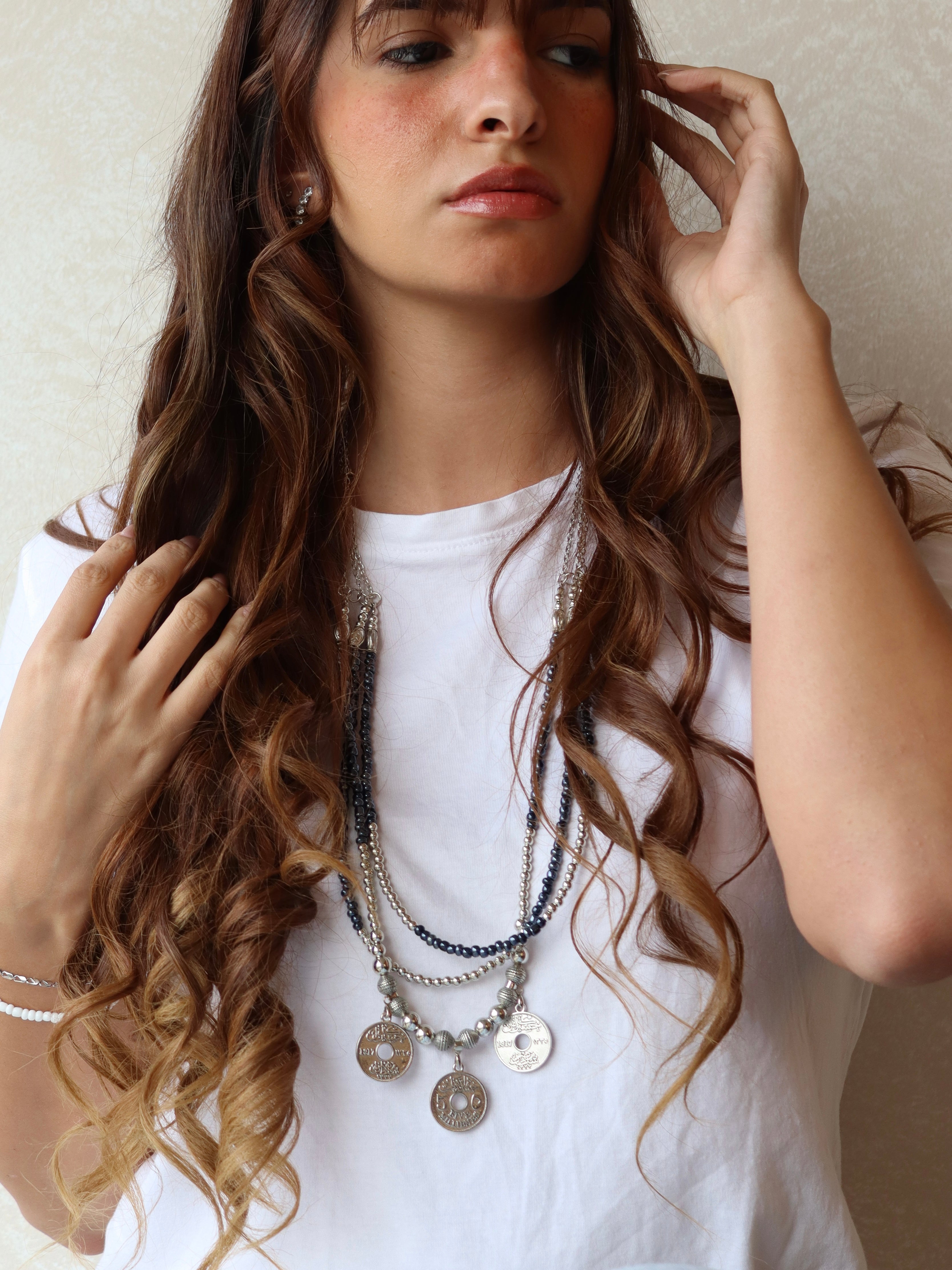 blue triple layered beaded necklace with three silver coins