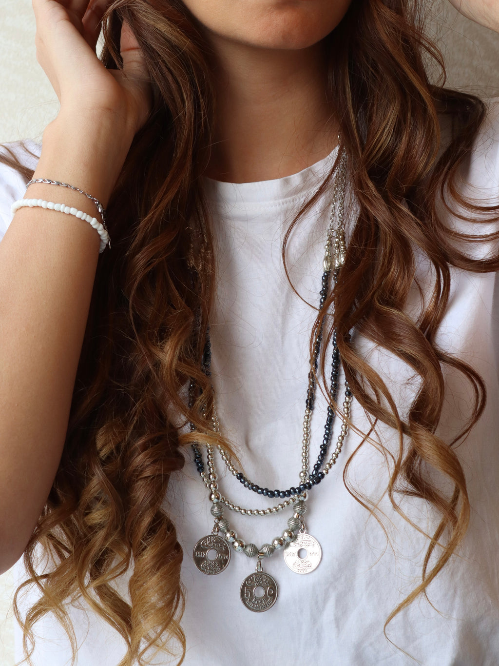 blue triple layered beaded necklace with three silver coins