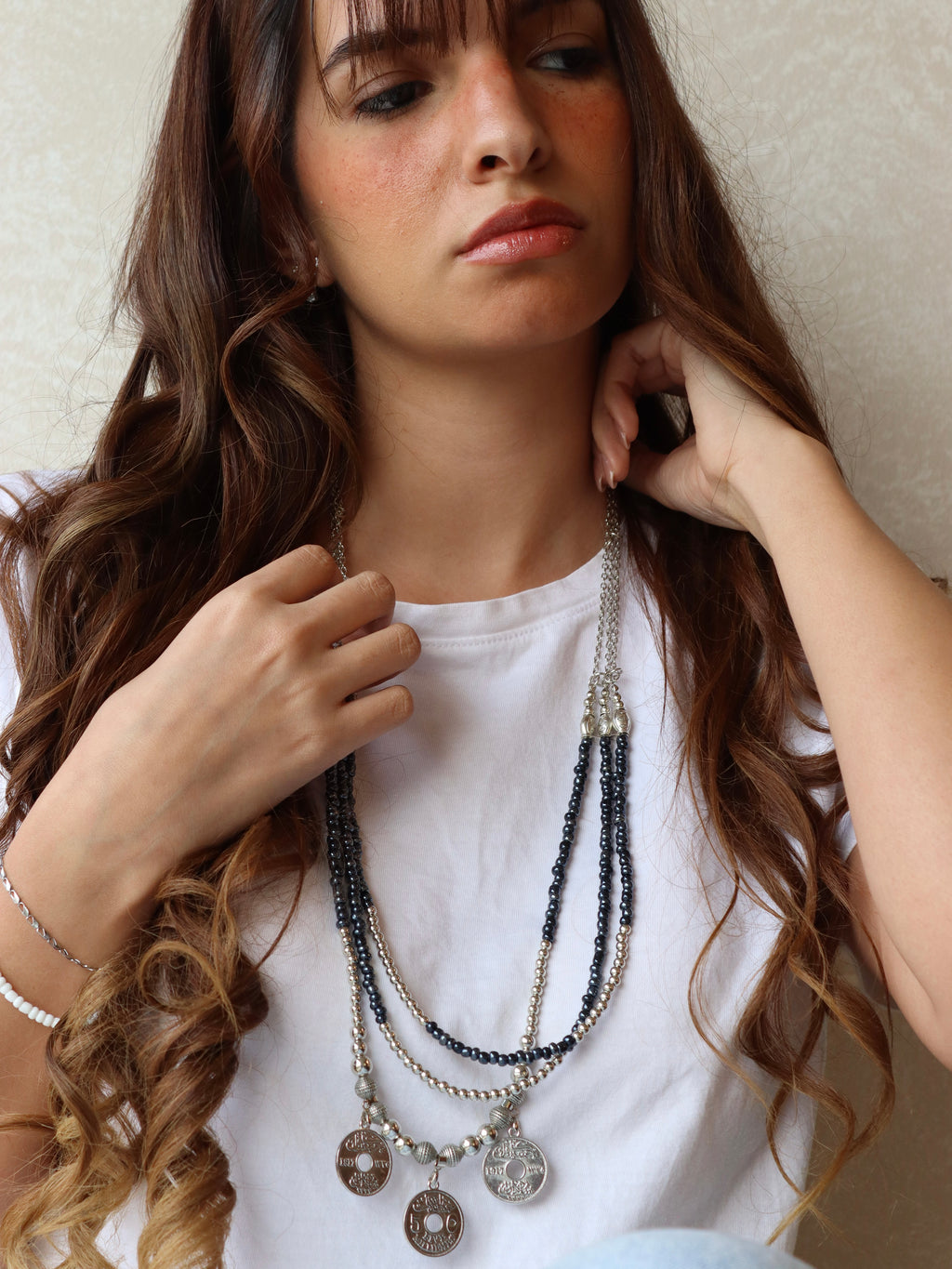 blue triple layered beaded necklace with three silver coins